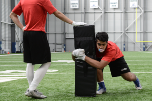 High School football player going through the Thigh and Roll tackling drill.