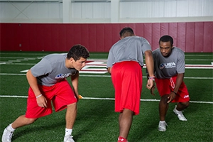 High School football player going through the Thigh and Drive tackling drill.