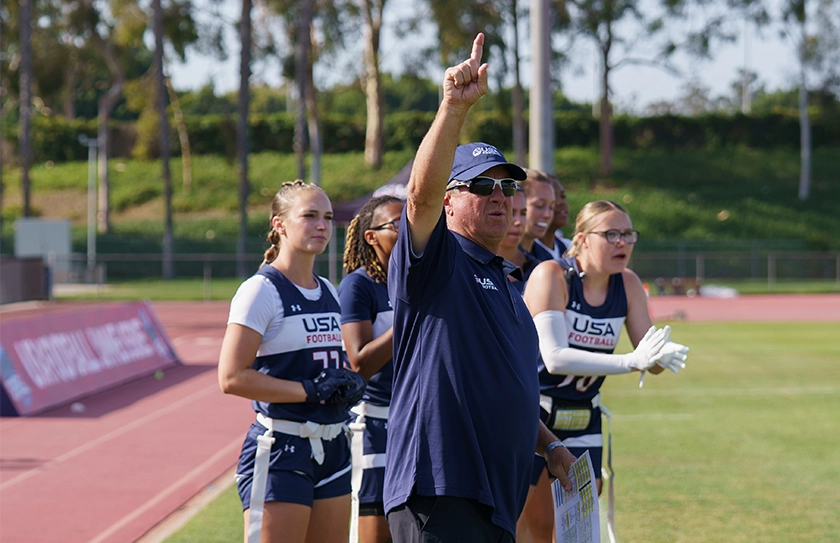 USA Football Select Bowl athletes on sideline during flag football tournament competition.