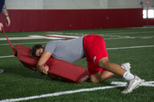 High School football player practicing fight to finish.