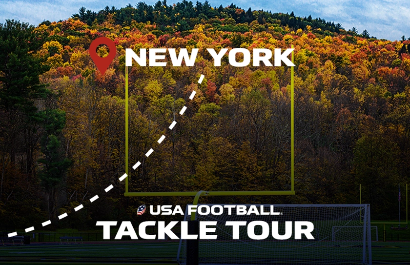 Football goalpost framing autumn trees in New York with USA Football Tackle Tour text overlay on a football field.